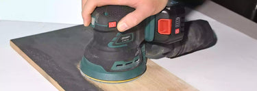 Using a cordless sander to refinish wooden planks