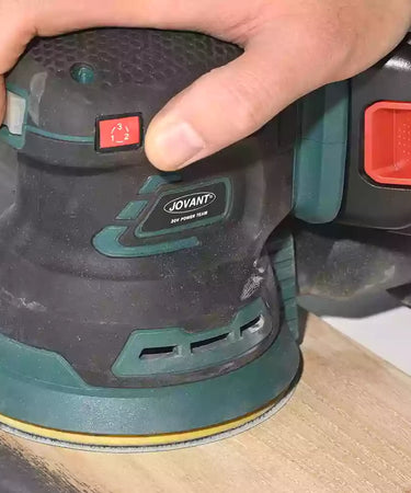 Using a cordless sander to refinish wooden planks
